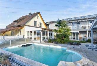 Einladende Poolanlage, eingerahmt von Altbau (gelb) und Neubau (grau)