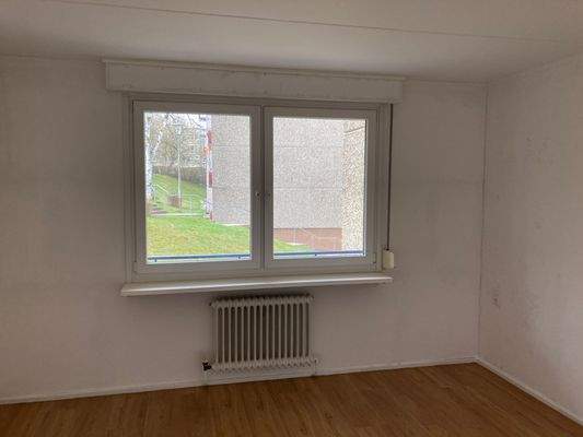 Schlafzimmer mit weiß grundierte Wänden, PVC Boden in Holzoptik, Fenster mit Blick in die Außenanlage