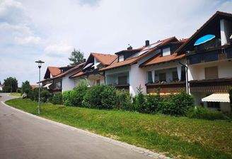 Ansicht von Westen mit Balkon und Anliegerstraße 