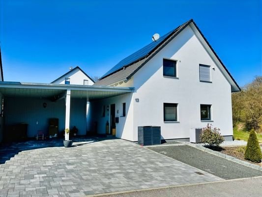 Ostansicht mit Hauseingang, Carport/Abstellhaus und Stellplatz
