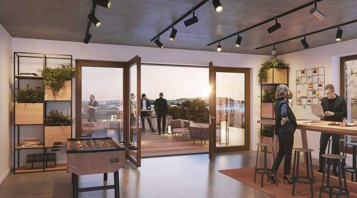 Modern eingerichteter Aufenthalts- oder Bürobereich mit Stehtisch, Tischkicker, Pflanzenregalen und geöffneter Tür zur Dachterrasse mit Blick ins Grüne.