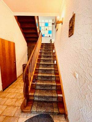 Treppenhaus mit breiter Holztreppe