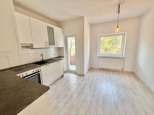 große Wohnküche mit Zugang auf den zweiten Balkon