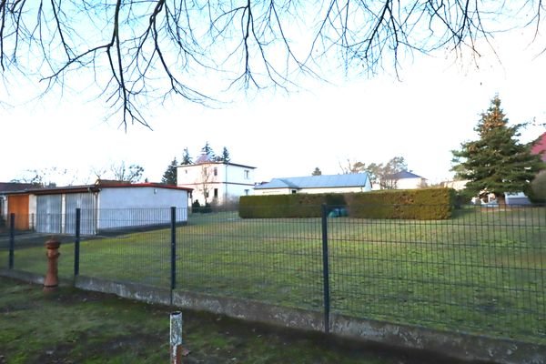 Ansicht mit Garage und kleinem Gartenhaus