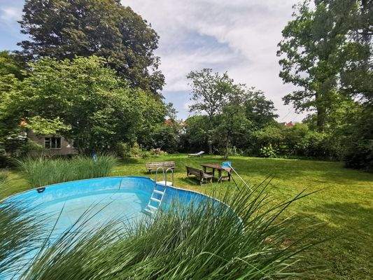 Gartenblick mit Pool, Bank und viel Platz – ideal zum Entspannen.