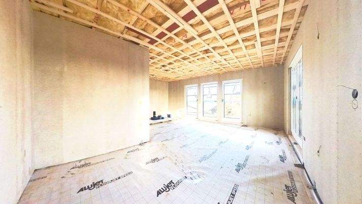 Blick von der Küche in den Wohnbereich mit Zugang zur zukünftigen Terrasse