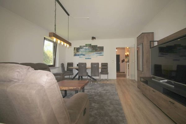 Wohnzimmer mit Blick auf Essbereich u. gläserne Eingangstür