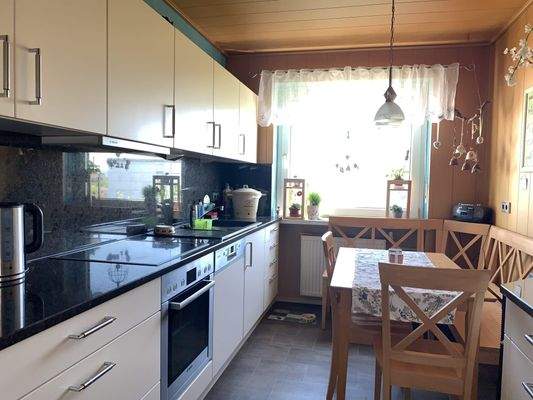 Küche mit modernen Einbaumöbeln und Essecke