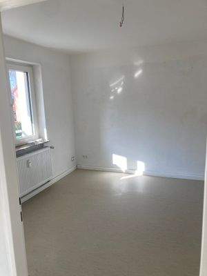 Kinderzimmer mit weiß angelegten Wänden und hellem Linoleumboden