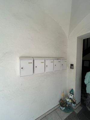 Weiße Briefkästen an Wand