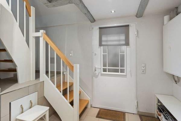 Eingangsbereich (Windfang | 6,87m²) mit Garderobe und Treppe ins Dachgeschoss.