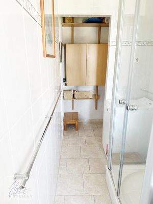 Tageslichtbad mit Dusche, WC, Waschtisch und Waschmaschienenstellplatz mit Blick Richtung Flurbereich (Verkauf ohne Inventar)