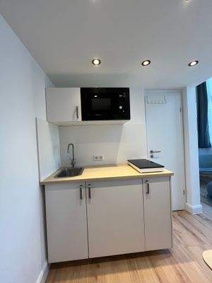 Küchenzeile mit Mikrowelle, Kühlschrank mit Gefrierfach, Kochfeld