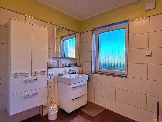 freundliches Badezimmer mit Fenster und Entlüftung