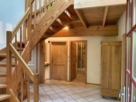 heller Flur mit Vollholztreppe