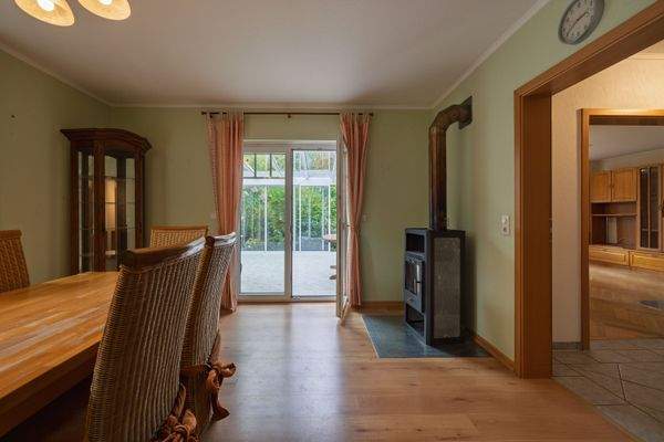 Essbereich mit Kamin und Wintergarten