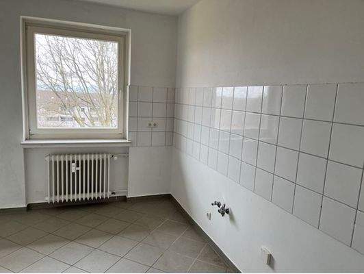 Küche mit hellgrauer Bodenverfliesung und weißem Fliesenspiegel.JPG