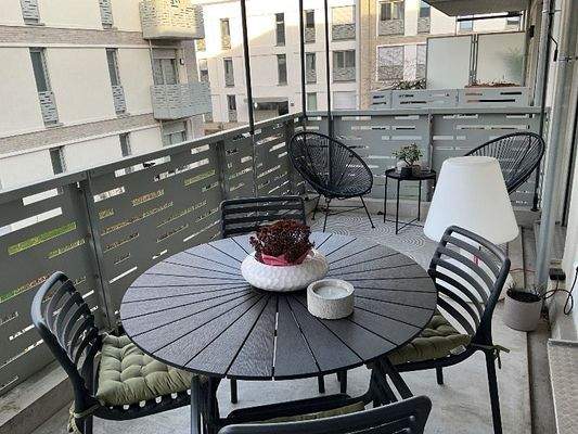 Balkon mit hellgrauer Brüstung, Blick in den Innenhof