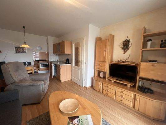 Offener Wohnbereich mit gemütlicher Sitzecke und durchdachter TV- und Stauraumlösung