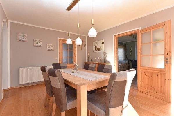 lichtdurchfluteter Essbereich mit angrenzender Küche 