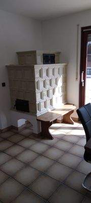 Esszimmer mit Kachelofen und Zugang zum Balkon