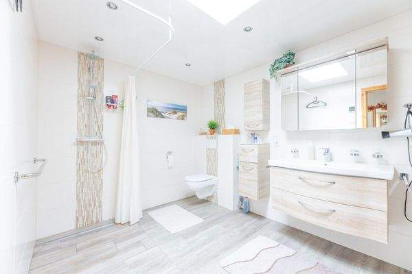 mit Einlaufdusche und Badmöbeln