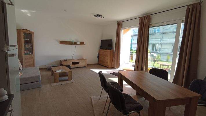 Wohnzimmer mit Schiebetür zu Terrasse und Garten