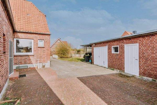 Hofbereich mit Nebeneingang auf beiden Seiten, angrenzend das Nebengebäude mit Garagen.