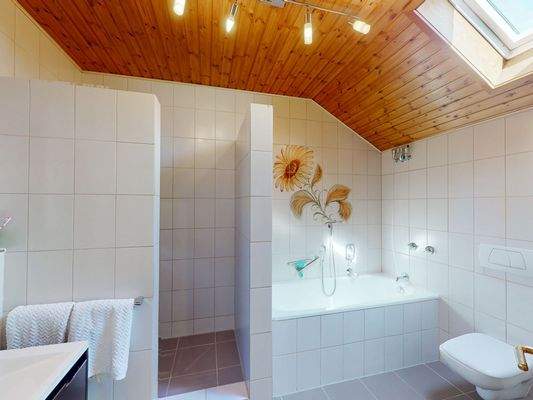 Stilvolles Wohlfühlbad mit Badewanne und Dusche im Obergeschoss.