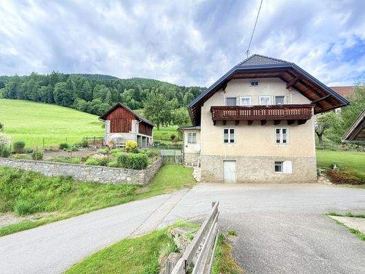 Haus außen mit Nebengebäude und Gemüsegarten