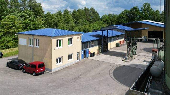 Blick auf das Bürogebäude, die Lagerhalle und die Produktionshalle