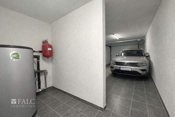 „Garage mit separatem Heizungsraum, aktuell baubedingt mit Material belegt – Visualisierung.“