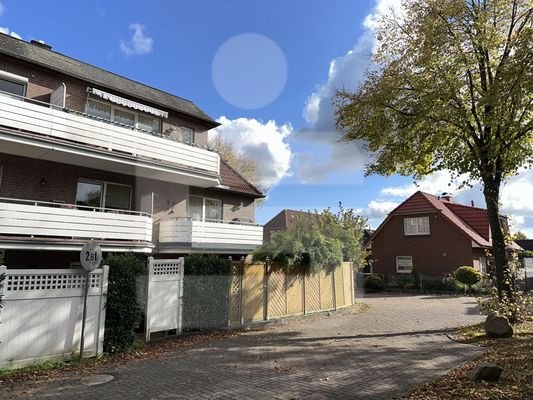 Blick von den Garagen zur Ausfahrt mit dem Garten hinter den Holzlamellenzaun