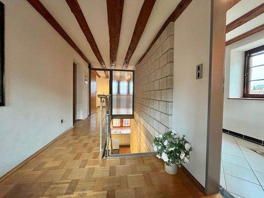 ehemaliger Gesinde- und Stalltrakt: heller Flur mit Zugang zu allen Räumen im Obergeschoss sowie dem Laubengang