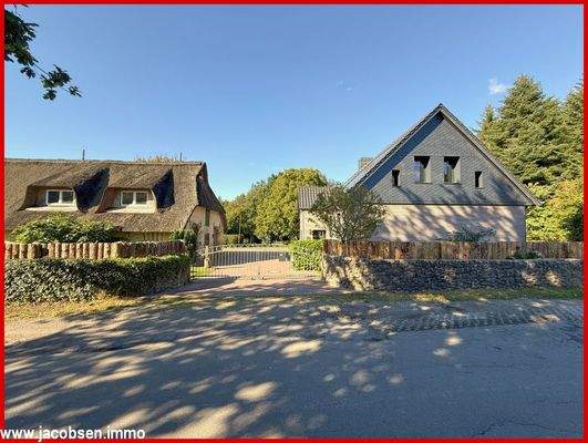 Straßenansicht mit Reetdachhaus und ehemaliger Försterei