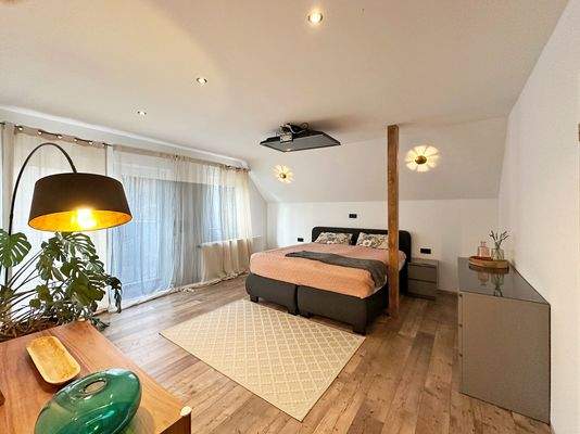 Großes Schlafzimmer mit Zugang zum Balkon im 1. Obergeschoss