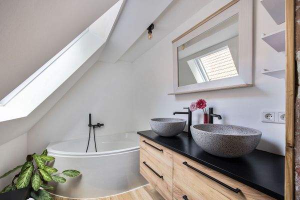 Modernes Tageslichtbad mit Eckbadewanne und modernem Waschtisch