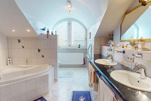 Stilvolles Badezimmer mit großer Eckbadewanne und Doppelwaschbecken