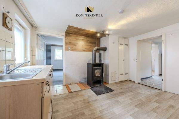 Küche mit Holzeinzelofen – Renovierungspotenzial.