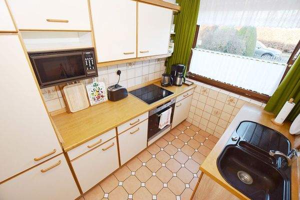 Die Küche mit Durchreiche zum Essplatz ist einfach ausgestattet.