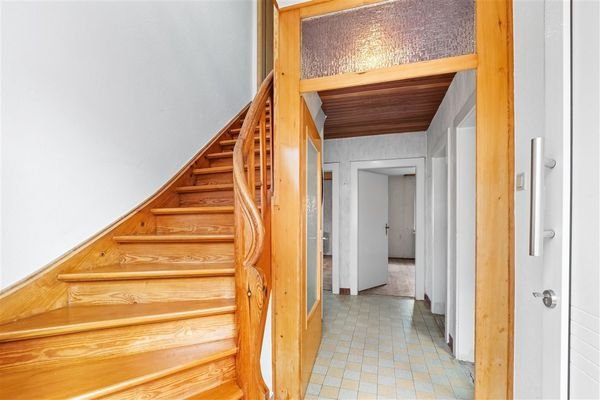 Die Holztreppe im Eingang verbindet EG und OG