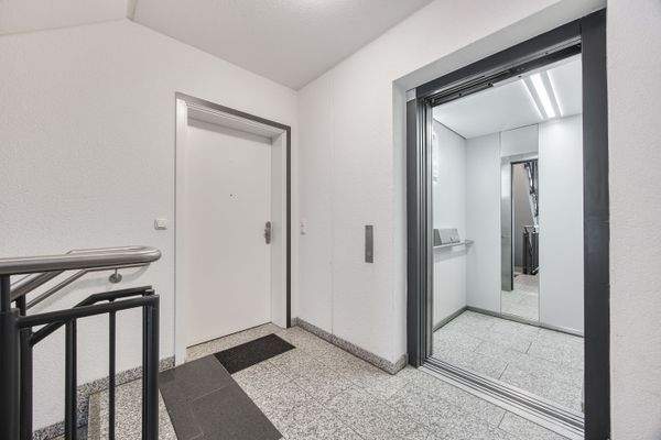 Einladender Eingangsbereich mit Aufzug und gepflegtem Treppenhaus