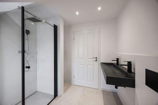 Ansprechendes, modern ausgestattetes Tageslichtbadezimmer mit Dusche, Doppelwaschtisch und WC