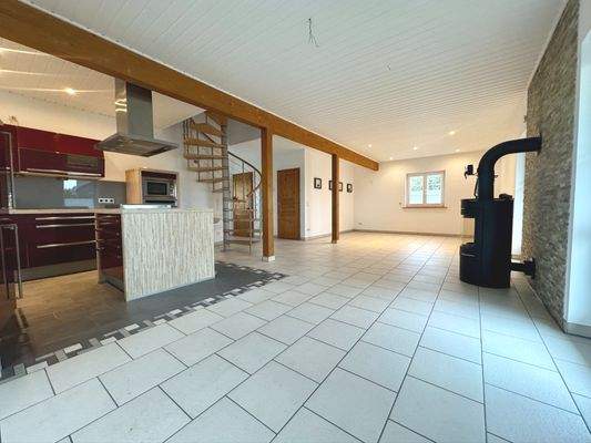 Wohnraum mit Kamin und offener Küche