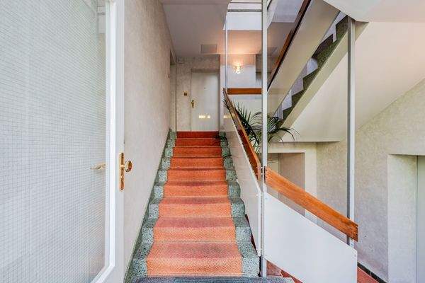 gepflegtes Treppenhaus mit rotem Teppich