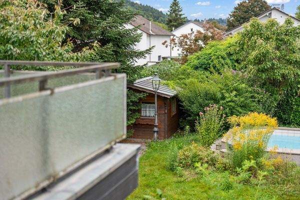 Blick über die Dachterrasse in Richtung Garten zum Pool und Gartenhaus 