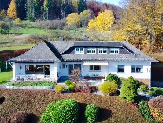 Frontansicht der Immobilie mit dem Eingangsbereich und der nach Süd-Ost ausgerichteten Terrasse