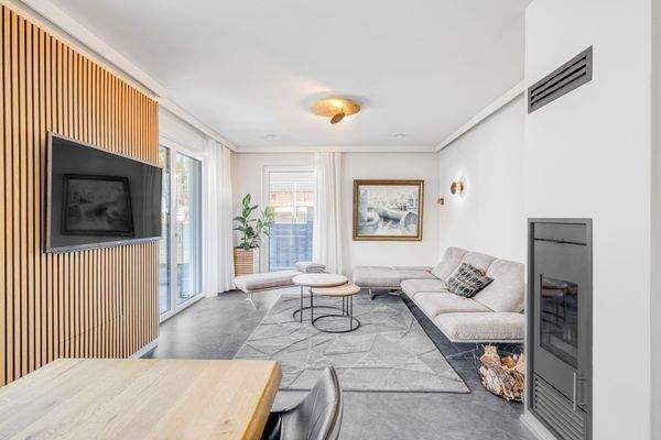 Lichtdurchfluteter Wohnbereich mit Kamin und direkten Zugang zur Terrasse