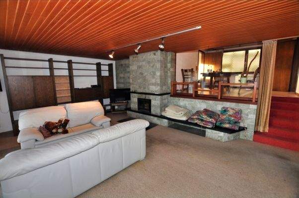 Wohnzimmer mit Kamin und Ausgang auf die Terrasse