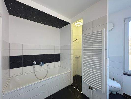 Badezimmer mit Badewanne und Dusche